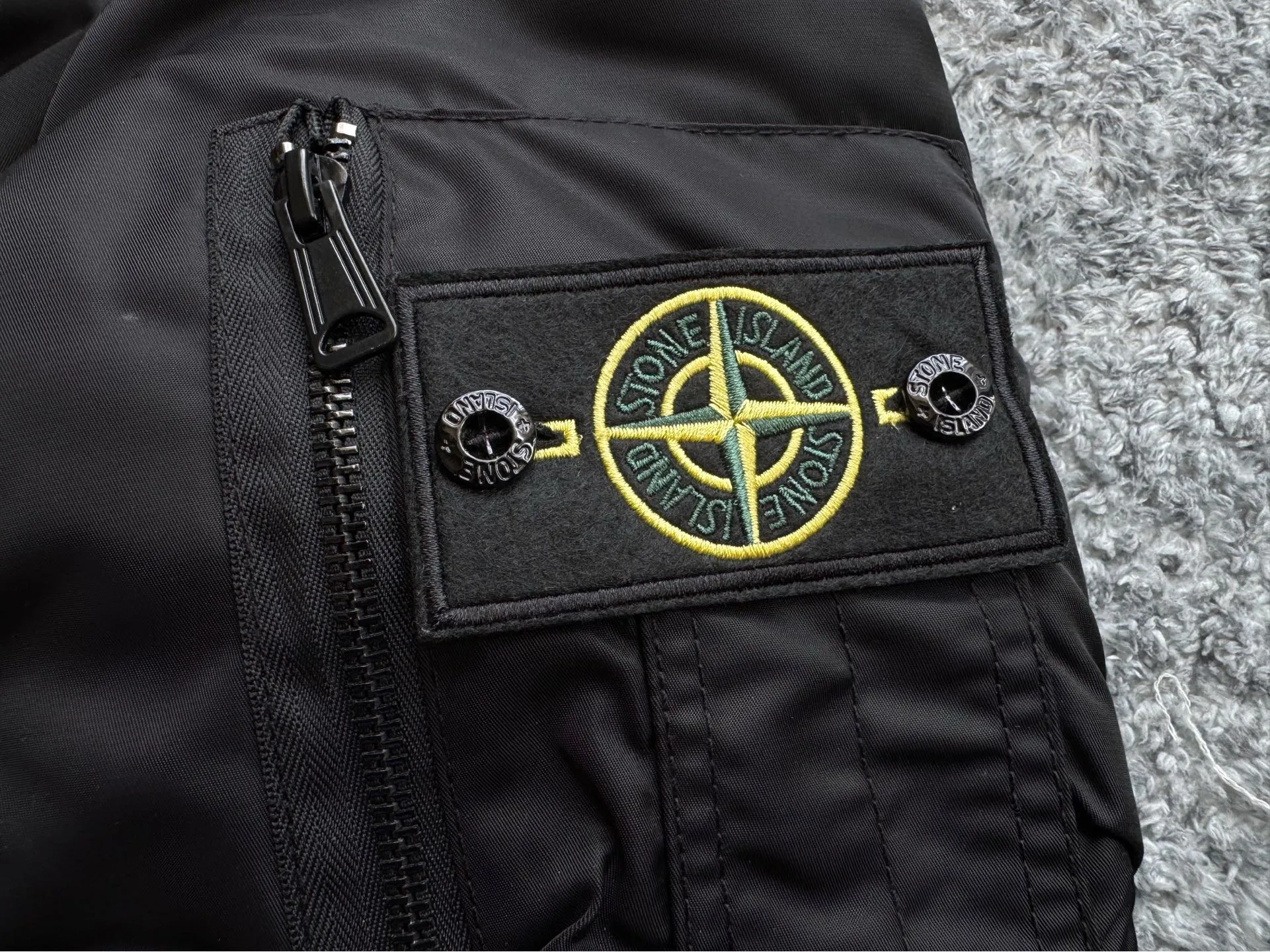 P360 Stone lsland Stone Island Medal Aviator Cotton Jacket The outer fabric is made of MA-1 flight nylon, which is a material specially used in flight and aviation. Flying nylon is a fabric specially used in flight and aviation. It is rarely used in ordinary clothing. The density of flying nylon is very high, so it is windproof and waterproof. When rain falls on the surface of the clothes, it will not penetrate immediately, but will form a small water droplet and slide off. This performance is a requirement for the development of modern jet technology. Because it is assumed that the pilot got caught in the rain before getting on the plane, he entered the cabin covered in rainwater. When flying at high altitude and at high speed, in a cabin without an environmental control system, water droplets will freeze on the pilot's body 2. Knitted baseball collar MA-1 uses a knitted collar. The collar is made of wool and can be snug around the neck and very warm. 3. Metal zippers We have very strict requirements on zippers, including smoothness and size. There was no zipper on the market that met the requirements, so we asked a zipper factory to customize a strong and durable metal zipper.  4. Double-threaded knitted cuffs The cuffs are made of double-threaded knitted fabric, narrow at the front and wide at the back. The narrow part can be tightened around the wrist to prevent wind from entering. The wide part has enough space when wearing multiple pieces under winter Color: Black Dark Army Green Size: M L.